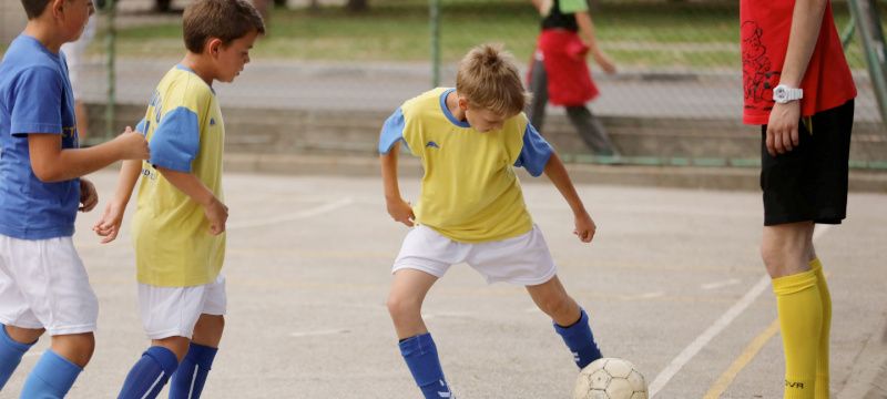 Child Playing Soccer in a yellow jersey.